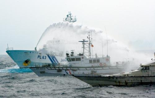 臺灣“海巡署”的巡邏船（中）在掩護(hù)保釣船“全家?！碧枺ㄓ遥┒惚苋毡竞Ｉ媳０矎d巡視船的水炮攻擊。