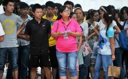 6月7日，雅安天全中學(xué)的呂莎莎老師(中)在考場(chǎng)外等待自己的學(xué)生出來(lái)。