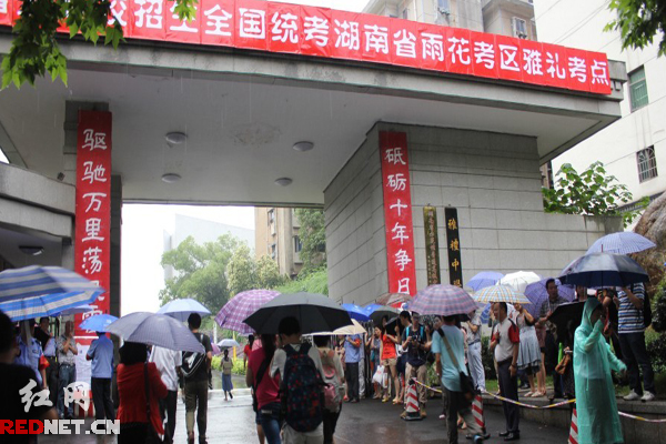 高考學(xué)子冒雨進入考場。