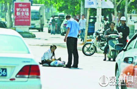 女孩從摩的上摔下，跌坐路中央，恰遇社區(qū)聯(lián)防巡邏人員扶起。