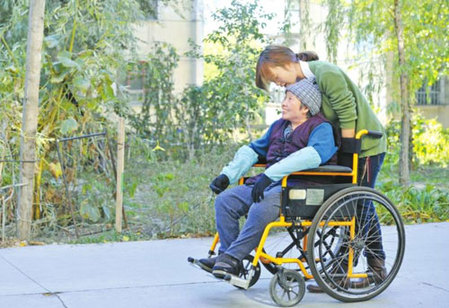10月11日，張學琴用輪椅推著母親在校園里散步。