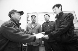 劉大爺莊重地將感謝信交到車隊隊長的手中。本報記者 李志華 攝