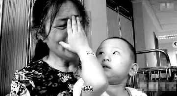 視頻中“小中寶”看到奶奶為他掉眼淚，就伸手為奶奶抹去眼淚。視頻截圖 