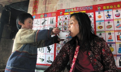 小孫悅為臥床的母親喂飯。