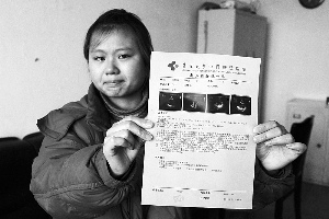 女孩眼含淚水向記者出示自己母親的診斷報(bào)告，希望好心人可以幫幫她的母親?！　z影 李自強(qiáng)
