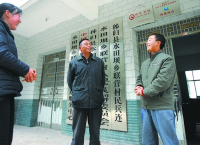  張義波(右)和村主任等村干部商談工作。