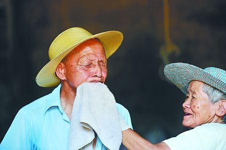 妻子黃茹杰正給丈夫雷卓禮擦汗水 　　本組圖片由記者 張路橋 實習(xí)生 程雯麗 攝