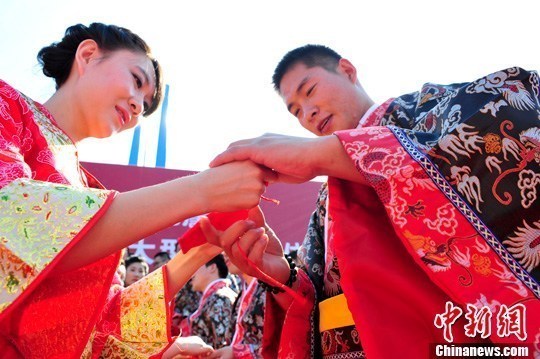 9月1日，一場別開生面的“重溫漢唐風(fēng)”漢式集體婚禮在泉城濟(jì)南舉行，72名新人身著傳統(tǒng)漢服喜結(jié)良緣，并在許愿墻上許下“千年共枕眠，一世永相愛”心愿。圖為新人解纓結(jié)發(fā)。中新社發(fā) 張勇 攝