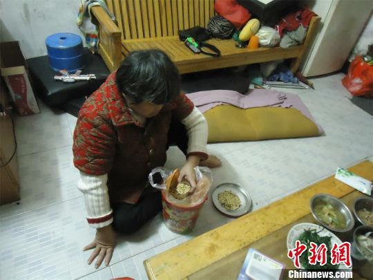 17日下午，56歲小兒麻痹癥患者張紅英爬在地板上找東西。 蘇路程 攝