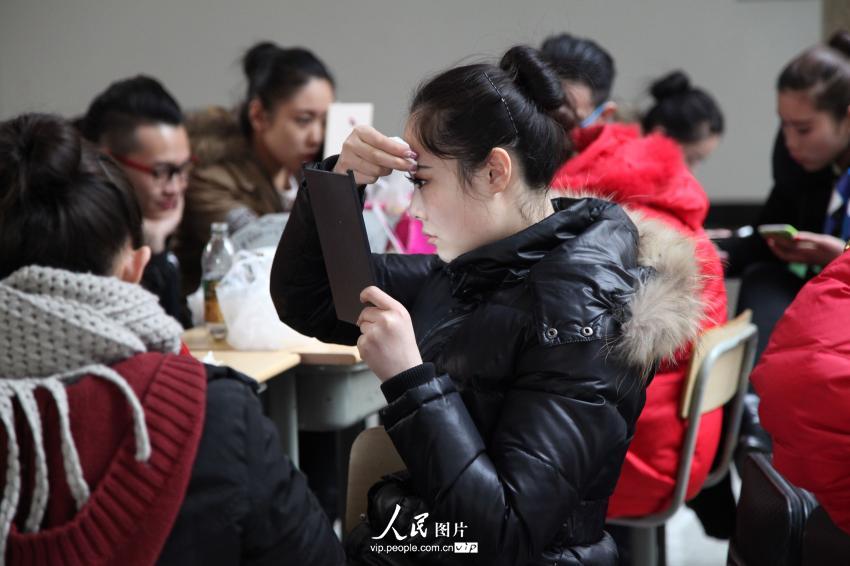 2014年2月17日，山東濱州，藝考候考考生在濱州學院報名點化妝。