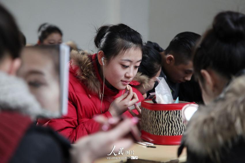 2014年2月17日，山東濱州，藝考候考考生在濱州學(xué)院報(bào)名點(diǎn)化妝。