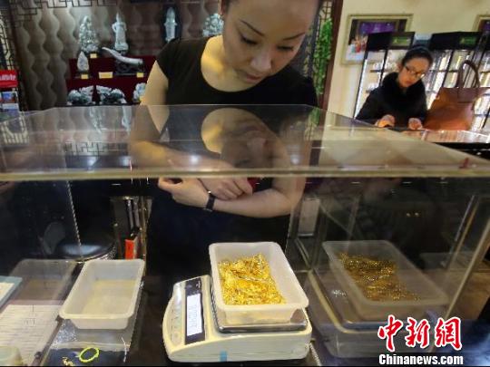 金店工作人員正在稱重?！?jiān)啤z