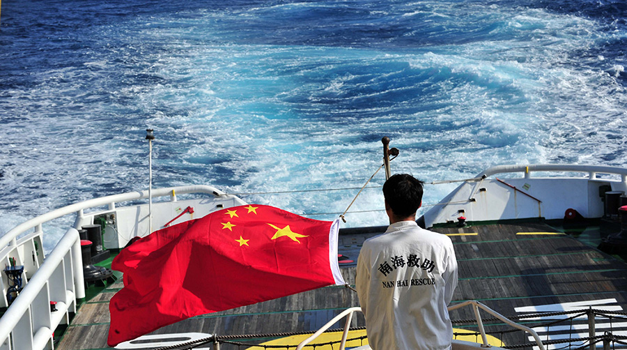 3月18日，水手李國棟在南海救101輪船甲板后部升起國旗。新華社記者 趙穎全攝
