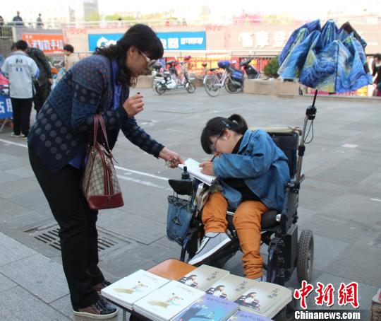 洛洛正在給買書的顧客簽名。 馮曉林 攝