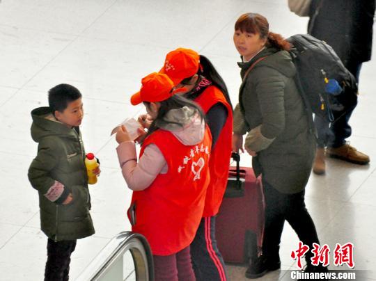 鐵路青年志愿者為攜帶兒童出行的旅客提供咨詢解答。　吳正琪　攝