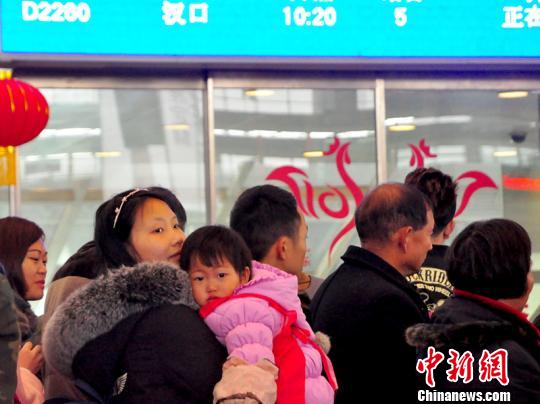一名兒童在母親的懷抱中候車。　吳正琪　攝